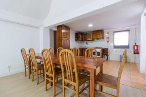 uma cozinha e sala de jantar com uma mesa de madeira e cadeiras em Guest House Ribeirinho - Alojamento local em Miranda do Corvo
