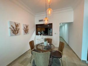 comedor con mesa de cristal y sillas en paradisíaco y hermoso apartamento, en Santo Domingo