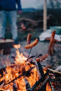 Ein Haufen Würstchen, die auf einem Grill kochen in der Unterkunft Osada Augustów in Mirsk