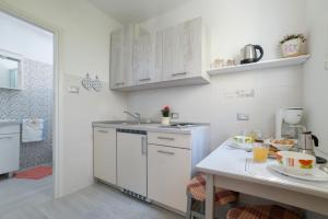 een keuken met witte kasten en een wit aanrecht bij Cozy Studio Near Beach in Baška