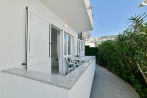 een balkon van een wit huis met 2 stoelen bij Cozy Studio Near Beach in Baška