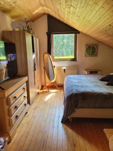 a bedroom with a bed and a mirror and a window at Au chant des oiseaux in Rochefort