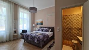 sypialnia z łóżkiem i przesuwnymi drzwiami w obiekcie Urban Haven w mieście Subotica