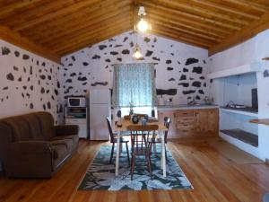 a kitchen and dining room with a table and a couch at Casa da Lavadia in Canto da Areia