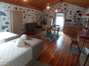 1 dormitorio con 1 cama y sala de estar en Casa da Lavadia, en Canto da Areia