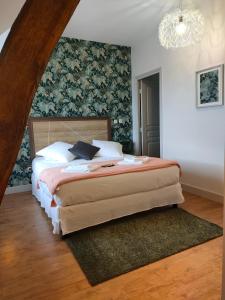 a bedroom with a large bed with a wall at Auberge des Colettes in Coutansouze