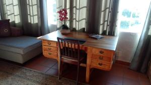 una scrivania in legno con una sedia e un vaso con dei fiori di Hilton Castle a Hilton