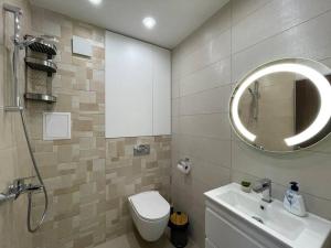 ein Badezimmer mit einem Waschbecken, einem WC und einem Spiegel in der Unterkunft Studio Green Зелено Студио in Burgas City