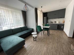 ein Wohnzimmer mit einem grünen Sofa und einer Küche in der Unterkunft Studio Green Зелено Студио in Burgas City