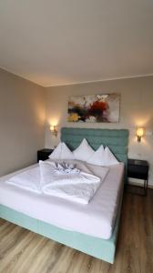 Hotel Residence MaVie في لاغوندو: غرفة نوم مع سرير أبيض مع اللوح الأمامي الأزرق