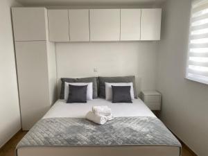 a bedroom with a large bed with white cabinets at Wellness Apartments Sunset in Zadar