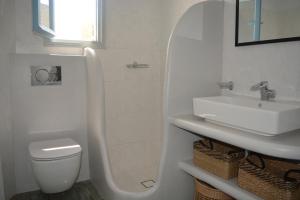 Baño blanco con lavabo y aseo en Klados Studios & Apartments, en Cherronisos