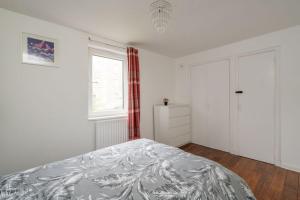 a white bedroom with a bed and a window at Entire City Center Cozy Flat in Edinburgh
