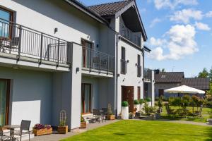 a house with a courtyard with a lawn at Akwamaryn in Grzybowo