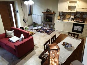 a living room with a red couch and a kitchen at Il tempio di Medusa in Zepponami +13 photos