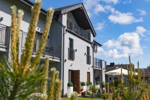 un edificio blanco con balcones y plantas en Akwamaryn en Grzybowo