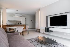 a living room with a couch and a table and a tv at Viam Imbriani Suites in Rome