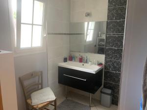 ein Bad mit einem Waschbecken und einem Spiegel in der Unterkunft Les 5 timbres in Montpellier-de-Médillan
