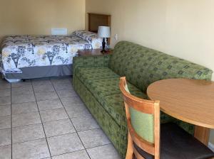 sala de estar con sofá, mesa y cama en Ocean Cove Motel en Virginia Beach