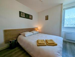 ein Schlafzimmer mit einem Bett mit zwei Handtüchern darauf in der Unterkunft Concept Appart'Hôtel - 202 in Saint-Brieuc