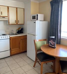a kitchen with a table and a white refrigerator at Ocean Cove Motel in Virginia Beach