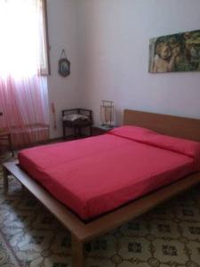 sypialnia z dużym łóżkiem i czerwonym kocem w obiekcie Casa accogliente e centrale a due passi dal mare w mieście Calasetta