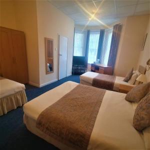 a hotel room with two beds in a room at Burley Court Hotel in Bournemouth