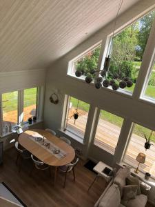 a living room with a table and some windows at Joarsbo, Stuga 3, Klinten in Kalv