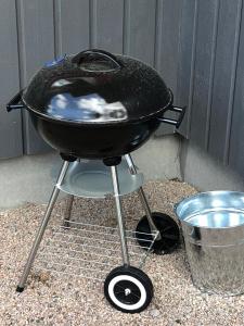 una parrilla sentada en un stand con un cubo en Joarsbo, Stuga 3, Klinten, en Kalv