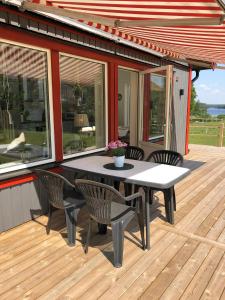 d'une terrasse avec une table et des chaises. dans l'établissement Joarsbo, Stuga 3, Klinten, à Kalv