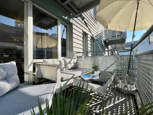 - une terrasse couverte avec des chaises et un parasol dans l'établissement Ruhe & Zentral! 2-Zimmer Kaiser-CITY-Appartement mit Balkon und Smart-TV in der Kaiserstraße in Karlsruhe beim Europaplatz, à Karlsruhe