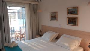 - une chambre avec un lit blanc et un balcon dans l'établissement Stefos Rooms, à Galissas