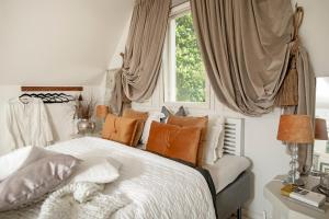 1 dormitorio con cama con almohadas y ventana en Villa Vivante, en Porvoo
