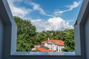 una vista a través de una ventana abierta de una ciudad en Emilia Lux Rooms en Vrnjačka Banja