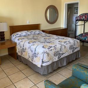 1 dormitorio con cama, mesa y espejo en Ocean Cove Motel en Virginia Beach