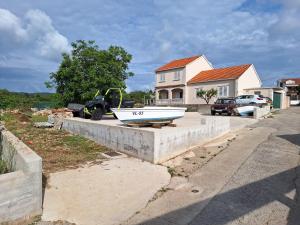 a boat sitting on a concrete wall in front of a house at Villa Gitta in Vela Luka