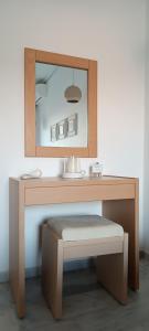 a dressing table with a mirror and a stool at Stefos Rooms in Galissas