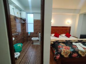 a bathroom with a bed and a sink and a toilet at Sikkimese Inn in Ravangla