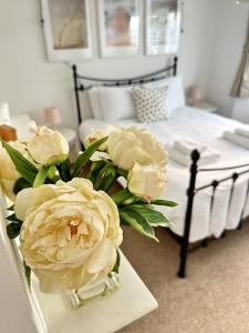 un vase de fleurs sur une table à côté d'un lit dans l'établissement Amazing Apartment, Private Garden, Off Street Parking, à Brighton et Hove