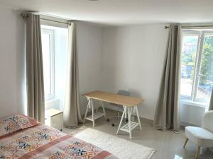 1 dormitorio con cama, mesa y ventanas en cocoon 52 m2 new, beautiful view castle and mountain, en Foix