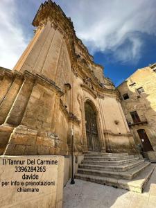 an old building with stairs in front of it at Tannur Del Carmine in Noto