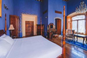 1 dormitorio con 1 cama en una habitación azul en La Casa de la Marquesa en Querétaro