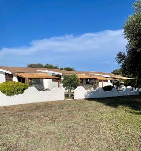 Camping Residence Chalet La Pomposa Terrazzoni في بونيفاسيو: منزل بجدران بيضاء وساحة