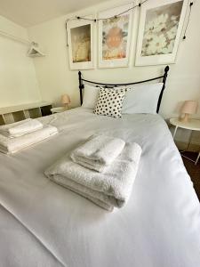 een wit bed met twee handdoeken erop bij Amazing Apartment, Private Garden, Off Street Parking in Brighton & Hove