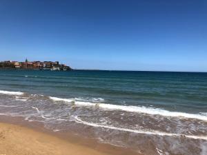 una playa con el océano y edificios de fondo en Apartamento Playa San Lorenzo Garaje opcional, en Gijón