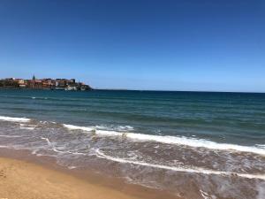 a beach with the ocean and buildings in the background at Apartamento Playa San Lorenzo Garaje opcional in Gijón