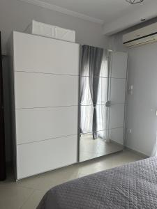 Schlafzimmer mit einer großen Glaswand und einem Bett in der Unterkunft Arya Guesthouse in Poligiros