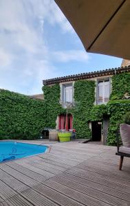 un edificio cubierto de hiedra con piscina en Maison de Vacances 8 à 15 pers à proximité du Canal du Midi, en Sallèles-dʼAude