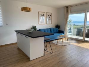 una cucina e un soggiorno con divano blu di Wellness Apartments Sunset a Zara (Zadar)