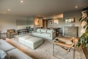 a living room with white couches and a table at Luxurious 1BR Overlooking Lima Golf Club in Lima